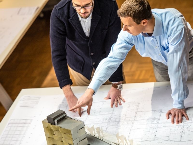 Engineering expert witness reviewing construction plans and project documents to evaluate a construction delay claim.
