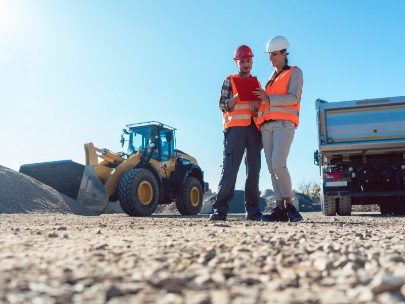 Transportation engineers reviewing plans at a development site while evaluating access and traffic improvements.