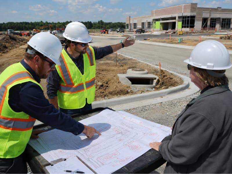 Municipal engineering reviews can change plans when engineers mark revisions on civil site plans at a commercial construction project